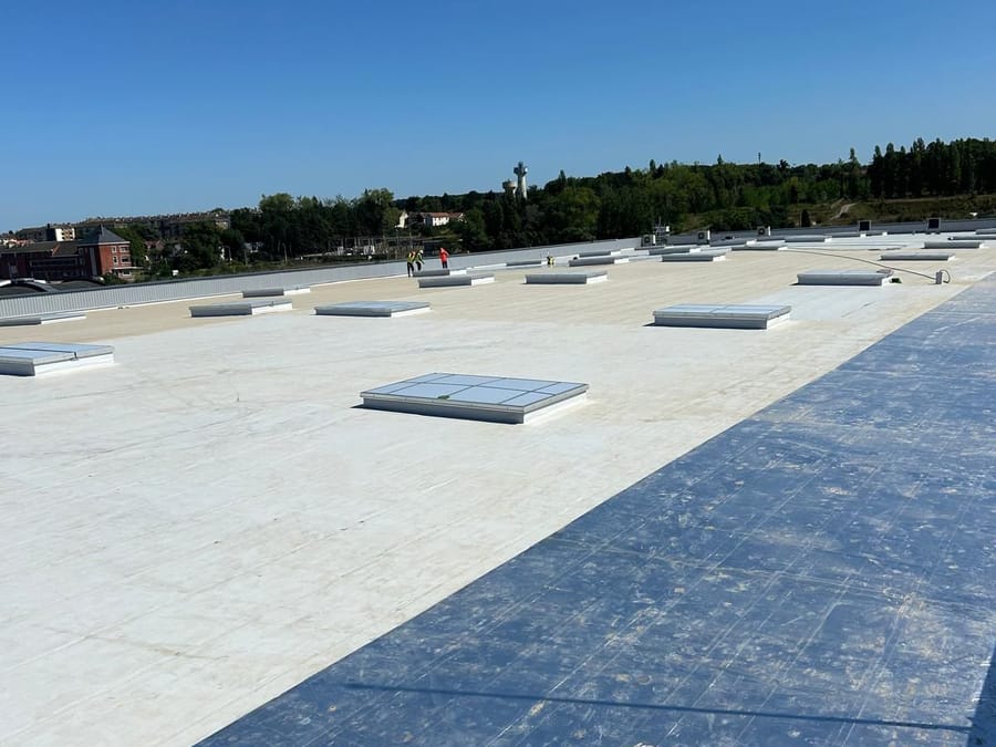 Toiture-terrasse en membrane blanche avec lanterneaux, après nettoyage