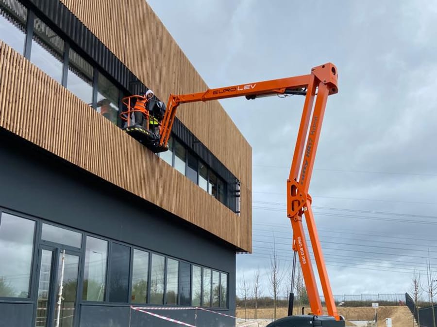 Nettoyage d'une façade en bardage bois depuis une nacelle articulée